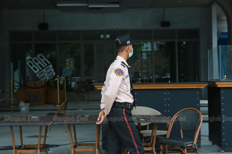 A security guard walks past a shuttered bar in Thong Lor area of Bangkok, the centre of a rapidly spreading new cluster of Covid-19. (Photo: Somchai Poomlard)