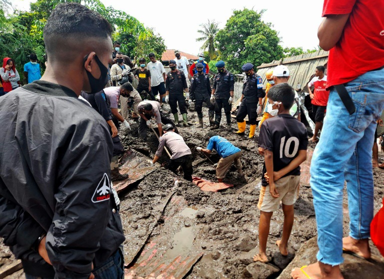 Residents watch rescuers extract mud-covered corpses from the debris in Lamanele village, East Flores, after torrehtial rains from Tropical Cyclone Seroja Residents watch rescuers extract mud-covered corpses from the debris in Lamanele village, East Flores, after torrehtial rains from Tropical Cyclone Seroja