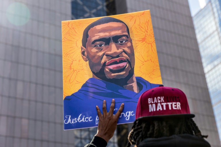 A demonstrator holds a sign with a picture of George Floyd during a protest outside the Hennepin County Government Center in Minneapolis, Minnesota, where former police officer Derek Chauvin is on trial A demonstrator holds a sign with a picture of George Floyd during a protest outside the Hennepin County Government Center in Minneapolis, Minnesota, where former police officer Derek Chauvin is on trial