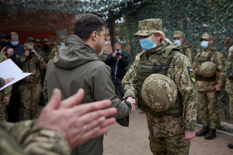 A masked President Zelensky greets an army officer in the eastern town of Zolote. A masked President Zelensky greets an army officer in the eastern town of Zolote.