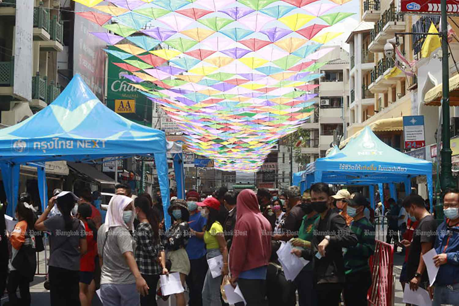 People queue up to take a Covid-19 test as two royally-sponsored mobile unit vehicles provided the service at Khao San Road on Wednesday following reports that an infected person visited entertainment venues in the area. (Photo: Arnun Chonmahatrakool)