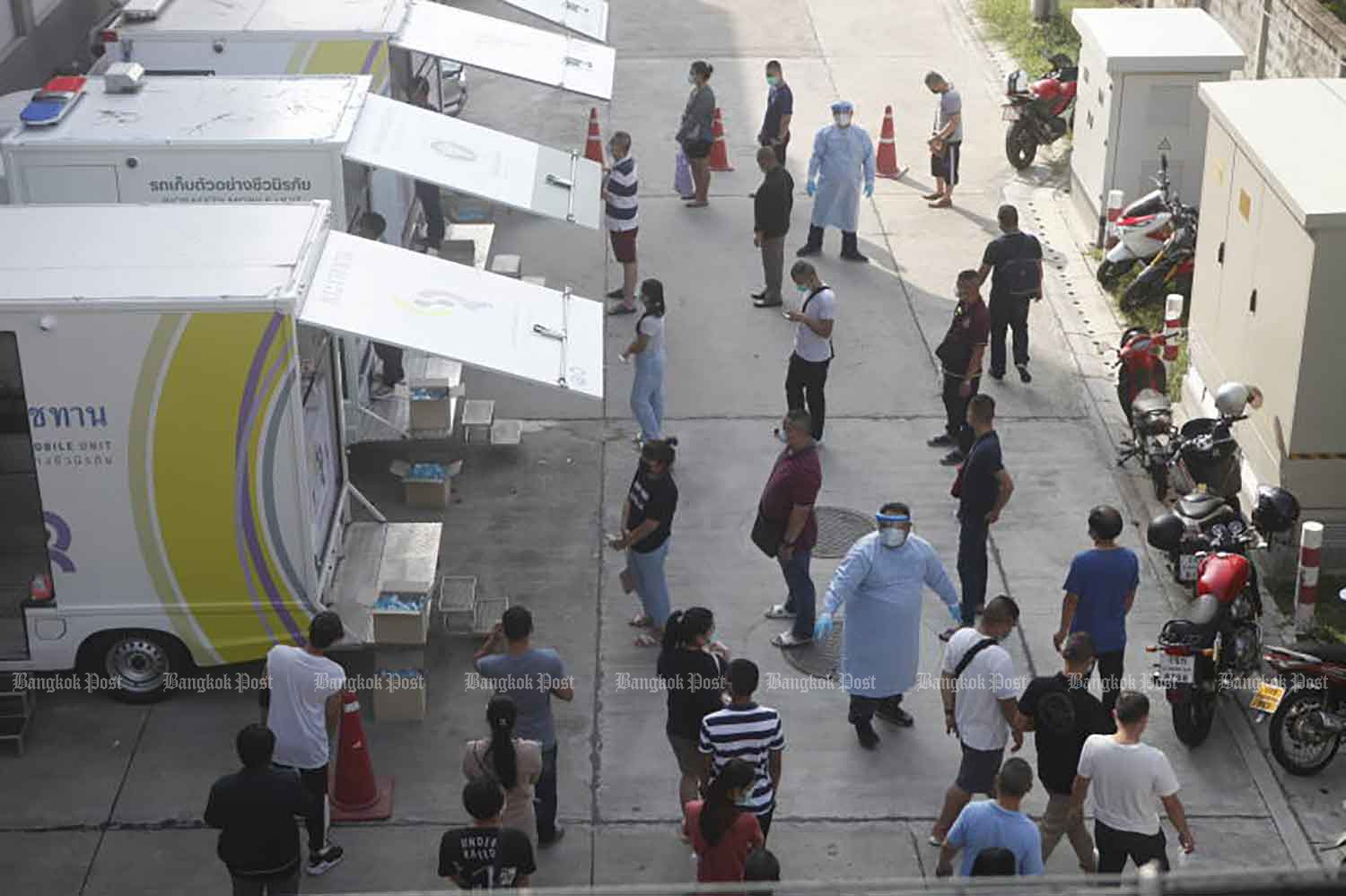 People queue up for Covid-19 tests from royally-donated mobile units at the Urban Institute for Disease Prevention and Control in Bang Khen district, Bangkok, on Wednesday. People can walk in for tests, without having to make appointments. (Photo: Nutthawat Wicheanbut)