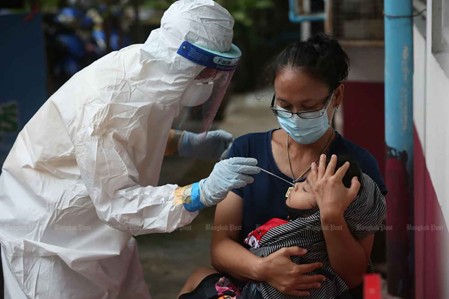 A health worker collects a nasal swab sample from the child for a Covid-19 test at Min Buri police station in Bangkok on Friday when the country made its new record of daily Covid cases. (Photo: Pattarapong Chatpattarasill)