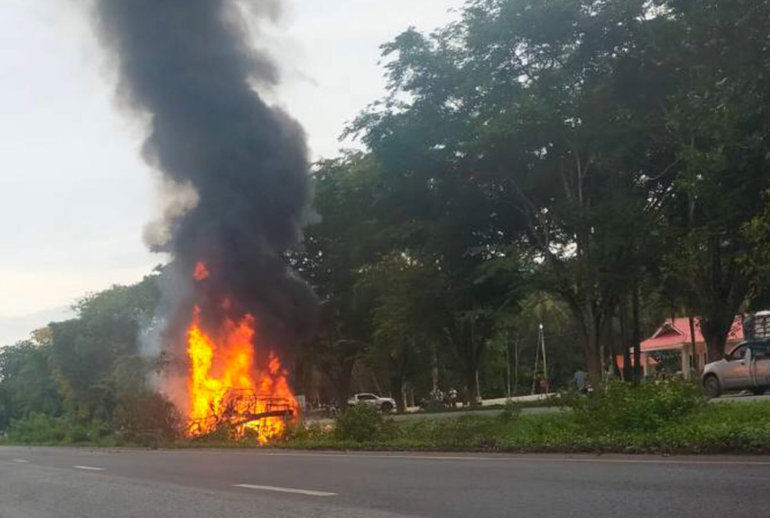 Flames rise from two pickup trucks on a road in Sai Buri district of Pattani after assailants opened fire on Saturday morning, killing three people inside the vehicles. (Photo: Abdullah Benjakat)