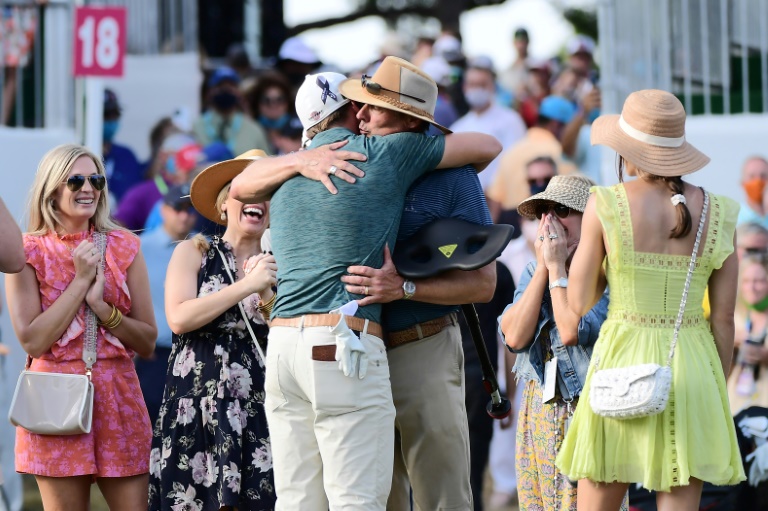 Sam Burns, his back to the camera, hugs his father as he celebrates with his family on the 18th green after winning his first US PGA title at the Valspar Championship. Sam Burns, his back to the camera, hugs his father as he celebrates with his family on the 18th green after winning his first US PGA title at the Valspar Championship.