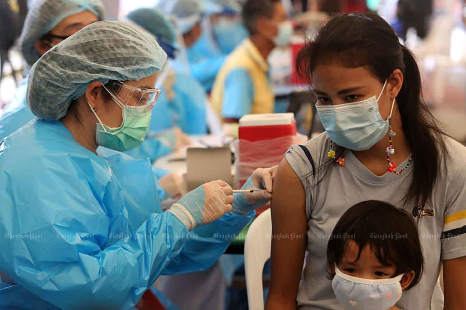 A woman is given a Covid-19 jab at Lotus Rama IV where an area has been converted into a vaccination venue for people in communities in Klong Toey in the capital where the virus has been spreading rapidly in recent days. (Photo by Wichan Charoenkiatpakul)