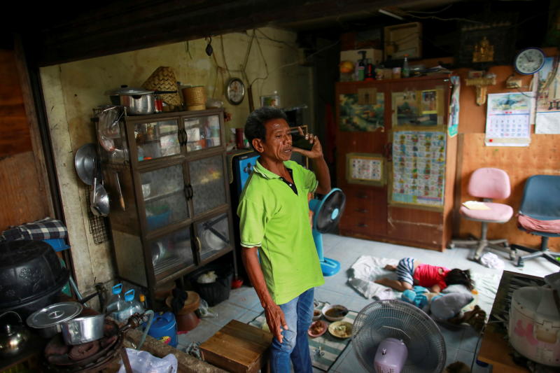 A man and a child are seen in a house in the Klong Toey slum in Bangkok on Tuesday. (Reuters photo)