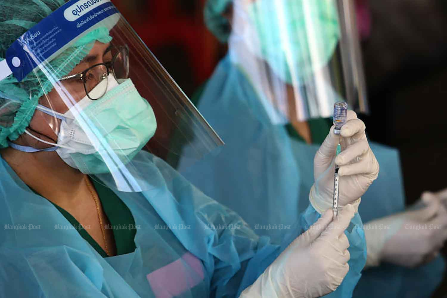 A medical worker prepares a dose of Covid-19 vaccine on Monday for injection at an old warehouse in Klong Toey, Bangkok, which has been converted into a mass inoculation venue. The site, located near the Port Authority of Thailand's head office, is the third to be set up in response to the growing number of infections in the capital's crowded districts. (Photo: Wichan Charoenkiatpakul)