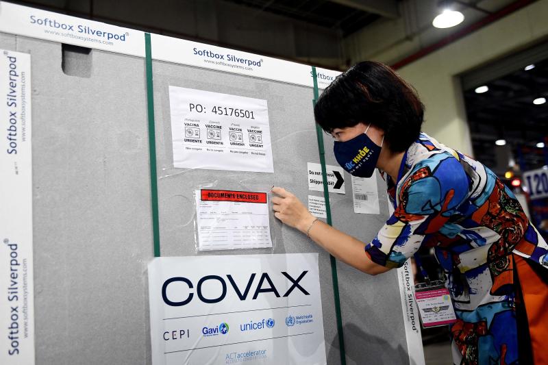 FILE PHOTO: A Health Ministry official checks documents on a container carrying the first shipment of the AstraZeneca/Oxford Covid-19 coronavirus vaccine doses, as part of the UN global Covax programme, as it arrives at the Noi Bai International Airport Cargo terminal in Hanoi on April 1, 2021. (AFP) FILE PHOTO: A Health Ministry official checks documents on a container carrying the first shipment of the AstraZeneca/Oxford Covid-19 coronavirus vaccine doses, as part of the UN global Covax programme, as it arrives at the Noi Bai International Airport Cargo terminal in Hanoi on April 1, 2021. (AFP)