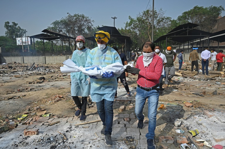 A volunteer carries the body of a child who died of Covid-19, at a crematorium in New Delhi A volunteer carries the body of a child who died of Covid-19, at a crematorium in New Delhi