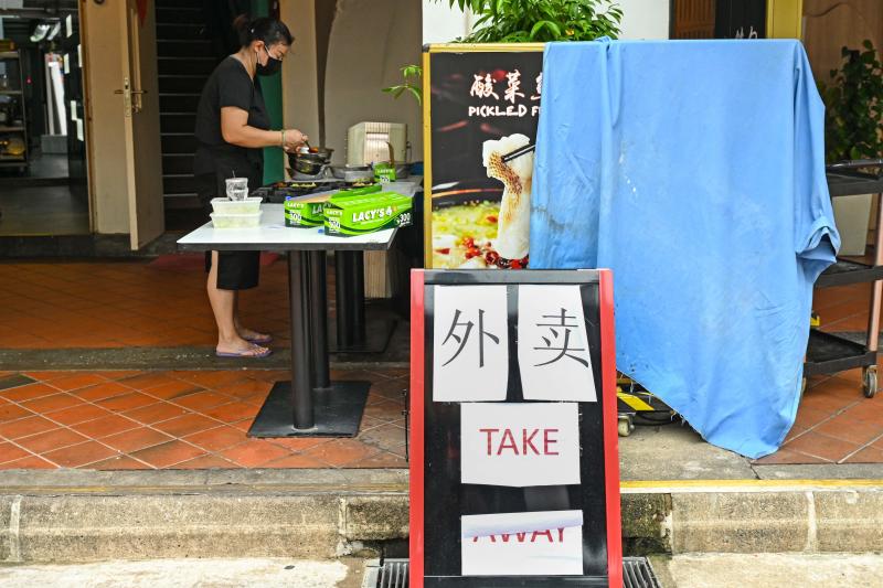 A worker prepares takeaway food orders at a restaurant along Boat Quay in Singapore on Wednesday as the country increased restrictions over concerns in a rise in the number of Covid-19 coronavirus cases. (AFP photo)