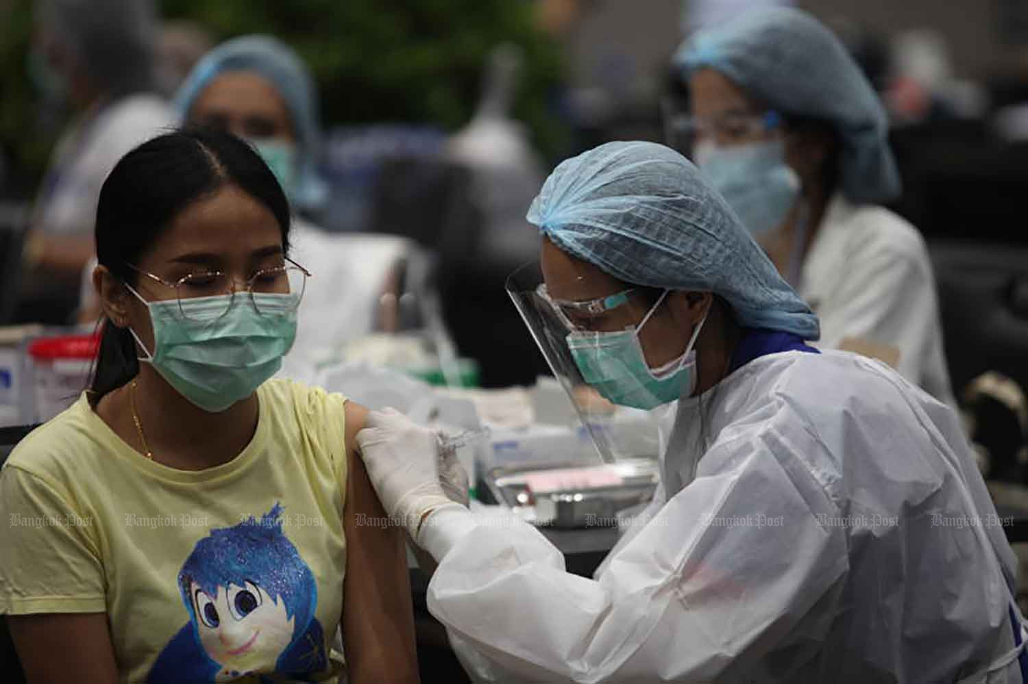 A woman gets her shot at a vaccination station in the Siam Paragon shopping mall in Bangkok on Friday. Services are reserved for members of specific groups who have registered and booked their jabs via the Mor Prome app. (Photo: Apichart Jinakul)