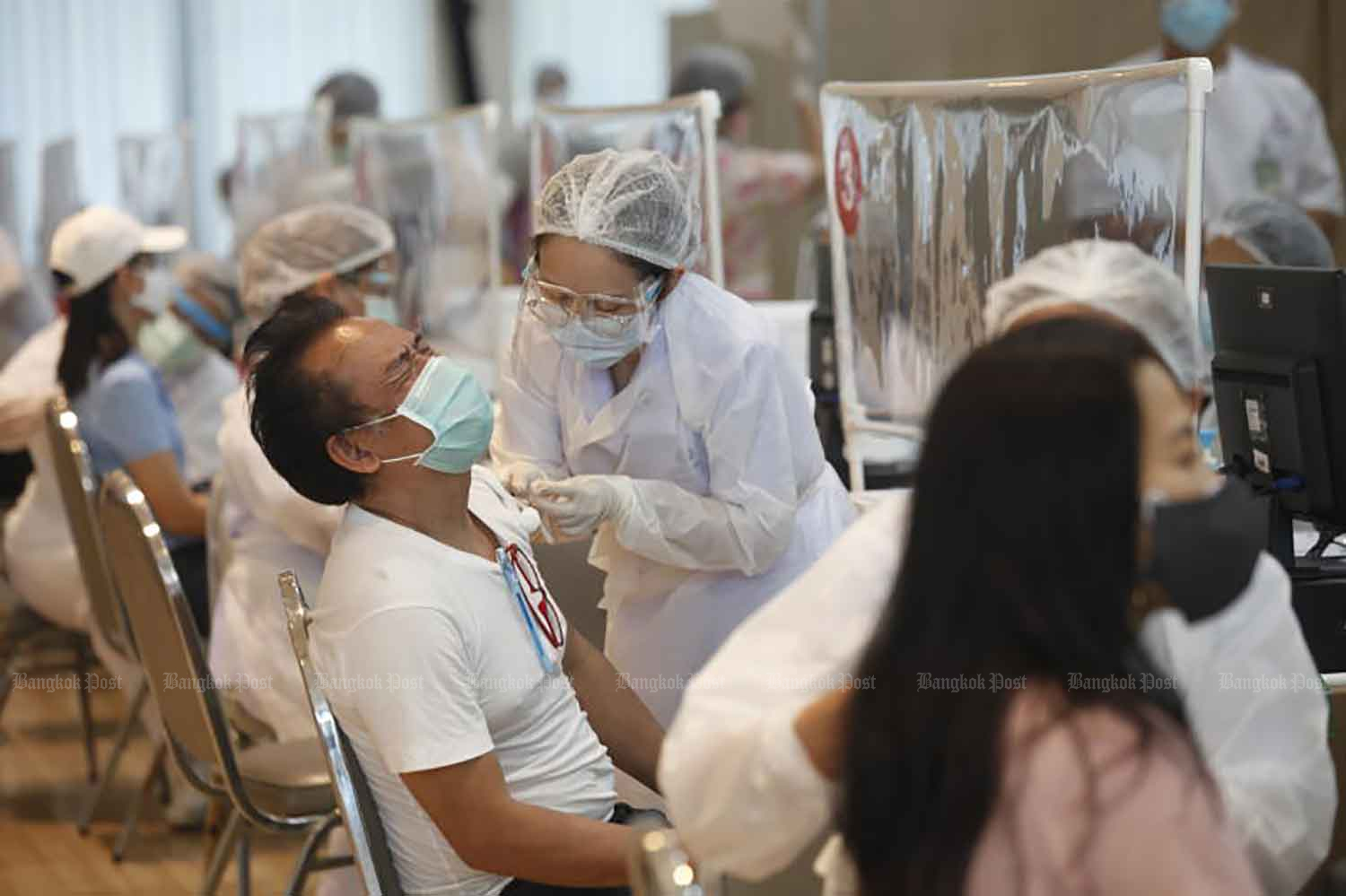 People receive Covid-19 vaccines at the University of the Thai Chamber of Commerce in Din Daeng district, Bangkok, on Tuesday when the country recorded its new high of daily Covid-19 fatalities at 41. (Photo: Nutthawat Wicheanbut)