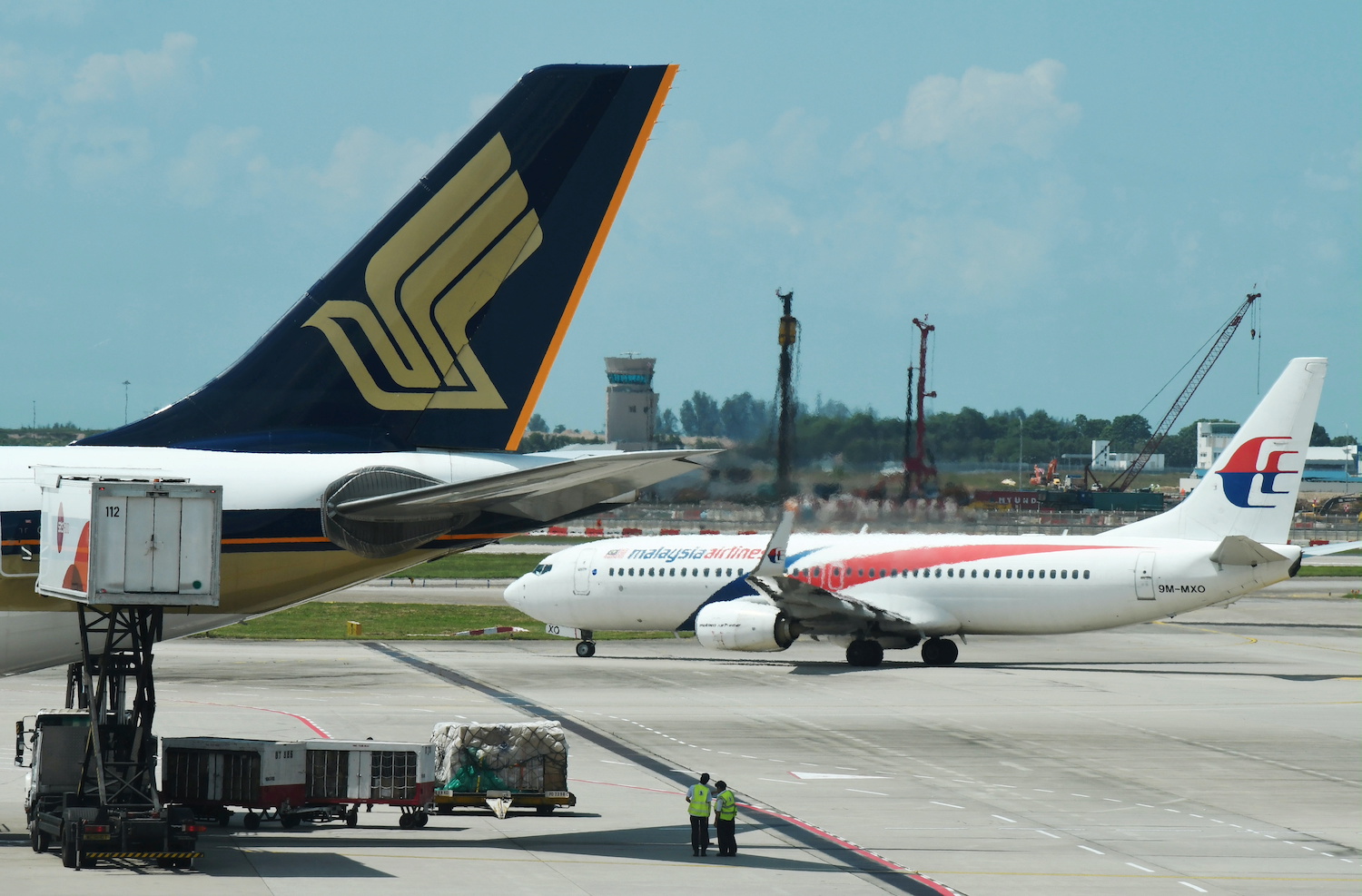 Malaysia Airlines and Singapore Airlines planes are pictured at Changi Airport in Singapore in July 2019. (Reuters File Photo) Malaysia Airlines and Singapore Airlines planes are pictured at Changi Airport in Singapore in July 2019. (Reuters File Photo)