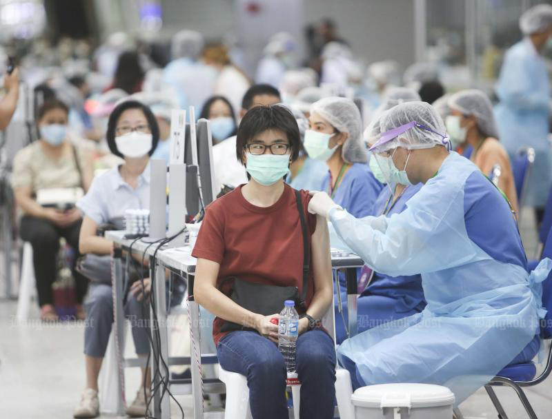 A health worker inoculates a woman at Bang Sue Grand Station after Prime Minister Prayut Chan-o-cha launched the nationwide vaccination drive on Monday. (Photo: Pattarapong Chatpattarasill)