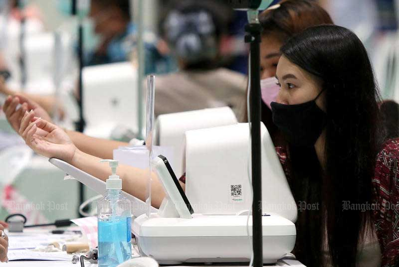 People prepare to receive a dose of the coronavirus vaccine at the Fashion Island shopping centre on Wednesday. (Photo by Varuth Hirunyatheb)