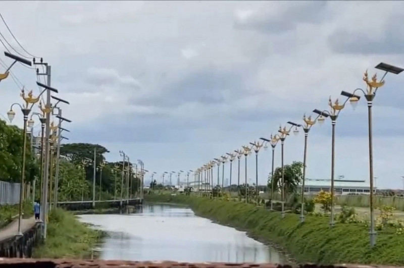 Closely spaced solar-powered lamp posts topped with mythical kinnaree figures line both sides of a flooded street in tambon Racha Thewa of Samut Prakan province. (Photo: Sutthiwit Chayutworakan)