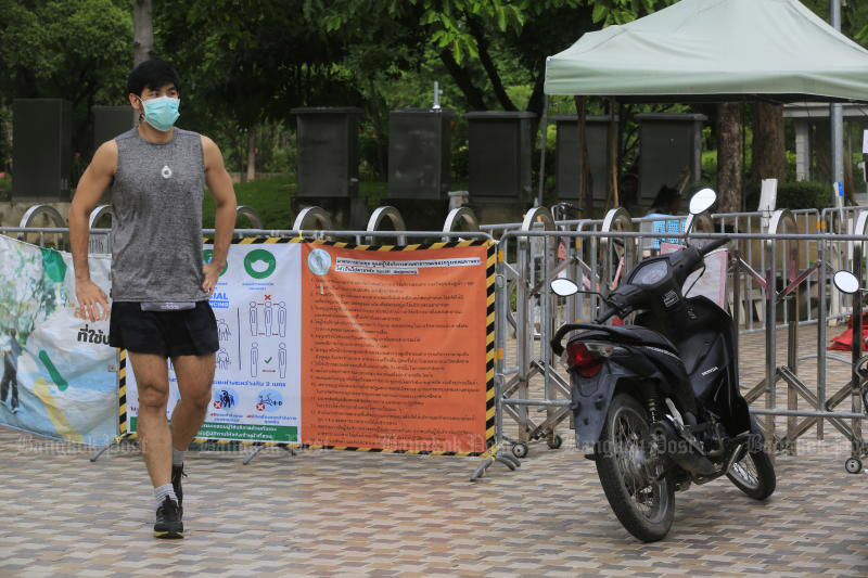 A disappointed jogger leaves Vachirabenjatas Park, or Suan Rot Fai, on Monday morning after arriving and finding the gates still closed. The city's parks finally reopened at 1pm for limited activities. (Photo: Pornprom Satrabhaya)