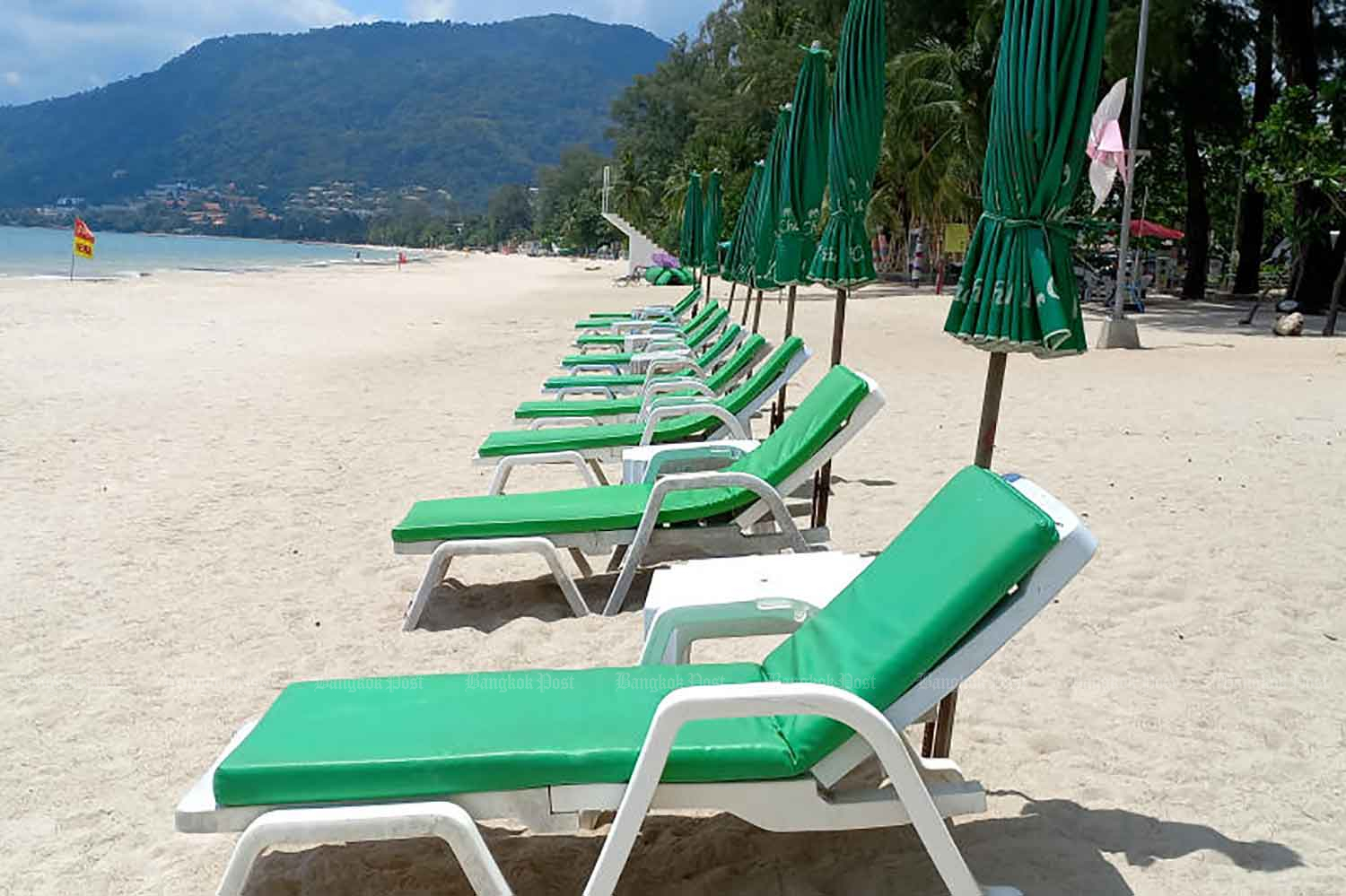 Beach chairs are placed on an empty beach in Phuket as the island province gears up for its July 1 reopening to tourists. (Photo by Achadthaya Chuenniran)