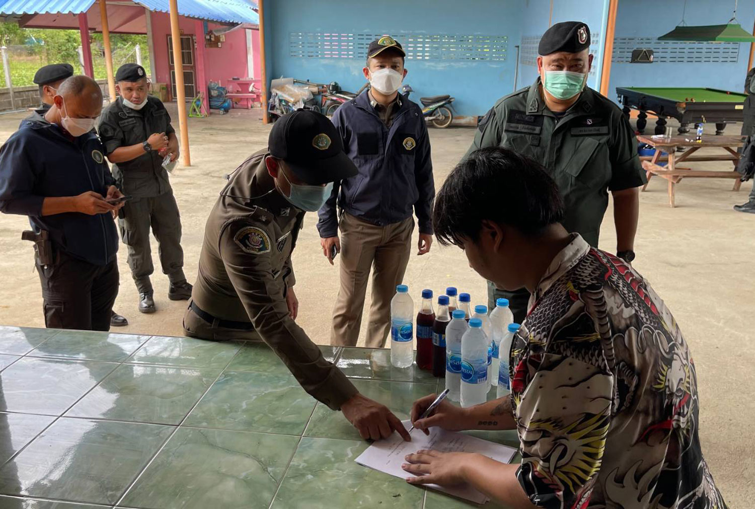 Police show a court warrant to the owner of one of the three houses searched in Suphan Buri on Thursday as part of an investigation into the international trade in wildlife destined for exotic restaurant dishes. (Police photo)
