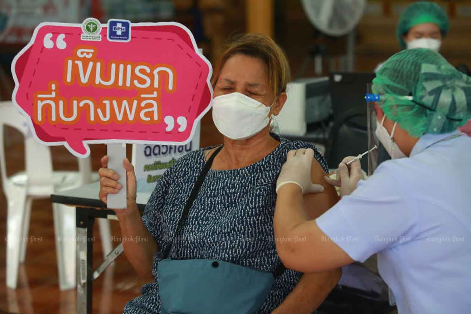 A woman holds a sign saying 