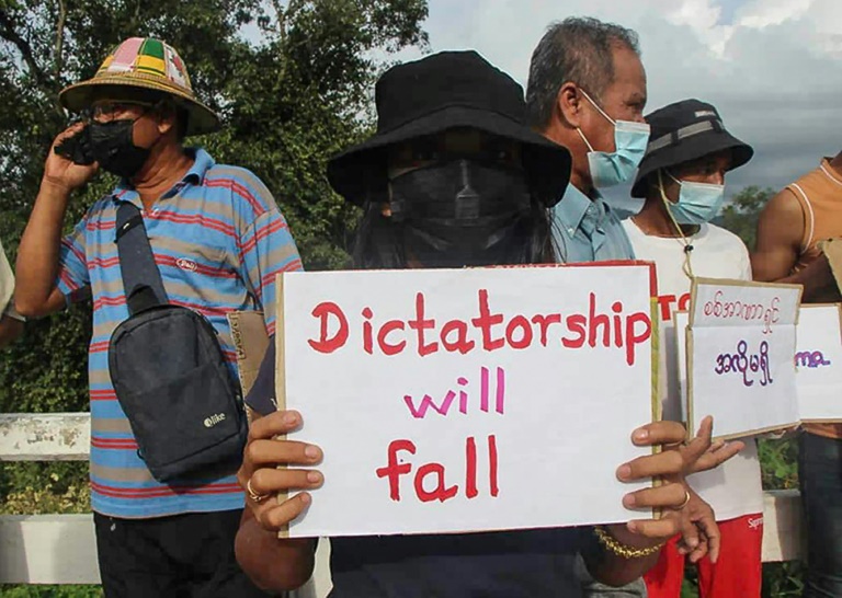 A protester holds a sign during a demonstration against the military coup in Myanmar's Karen state. A protester holds a sign during a demonstration against the military coup in Myanmar's Karen state.