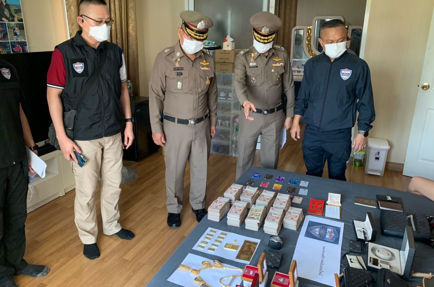 Officers from the Police Cyber Taskforce seize 4.4 million baht in cash, gold necklaces, computers and other items during a raid on two houses in Thanyaburi district in Pathum Thani on Thursday. (Police Cyber Taskforce photo) Officers from the Police Cyber Taskforce seize 4.4 million baht in cash, gold necklaces, computers and other items during a raid on two houses in Thanyaburi district in Pathum Thani on Thursday. (Police Cyber Taskforce photo)