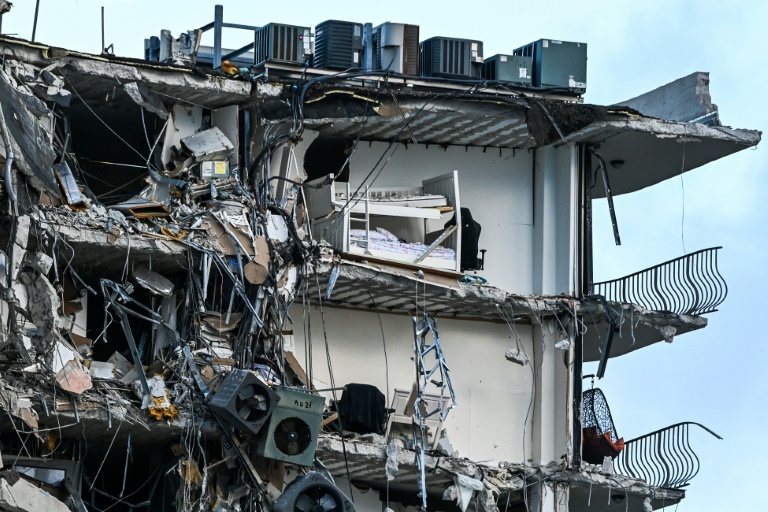 Rubble hangs from a partially collapsed building in Surfside north of Miami Beach, on June 24, 2021 Rubble hangs from a partially collapsed building in Surfside north of Miami Beach, on June 24, 2021
