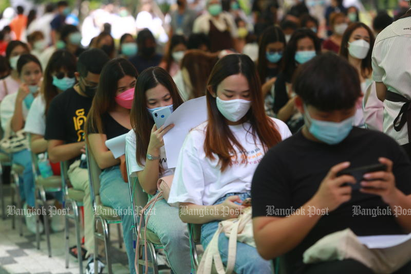 Students wait for Covid-19 vaccinations at the University of the Thai Chamber of Commerce in Bangkok on Thursday. (Photo: Somchai Poomlard)