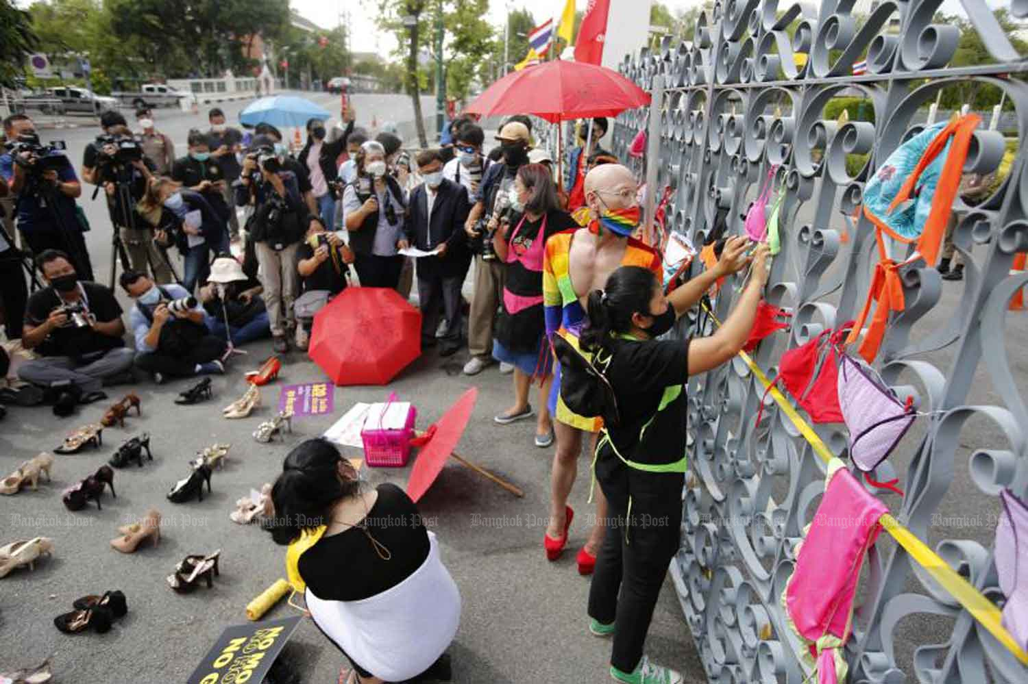 Representatives of nightlife workers display high-heels and hang bikinis on the gate of Government House during their rally demanding a monthly handout to survive the Covid-19 crisis after the government closed their workplaces early last year. (Photo: Wichan Charoenkiatpakul)