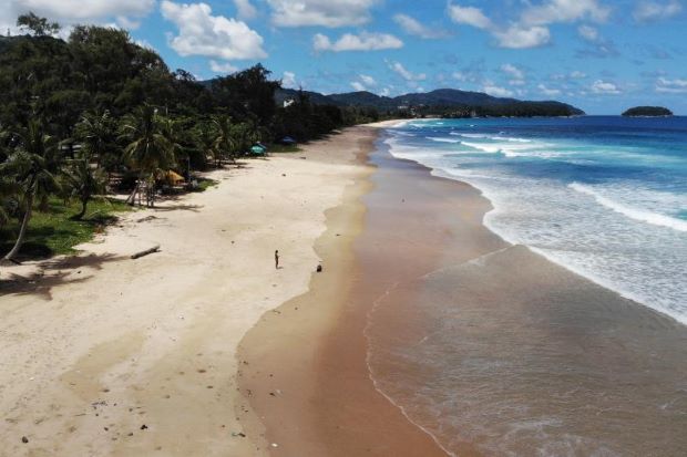 An aerial photograph shows a lone visitor on Karon Beach on Wednesday, one day before the “Phuket Sandbox” tourism scheme that allows visits by people vaccinated against the Covid-19 coronavirus is set to launch. (AFP photo)