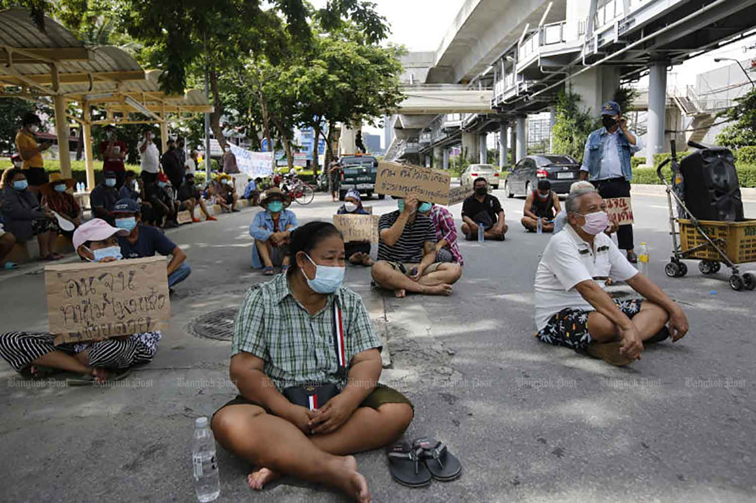 People from a community on Soi Sukhumvit 70/2 stage a sit-in on Sukhumvit Road near Bang Na intersection in Bangkok on Wednesday to demand that neighbours infected with Covid-19 receive treatment in hospital. They fear a community outbreak if the infected are forced to remain at home. They claim at least 20 people are infected. (Photo: Wichan Charoenkiatpakul)