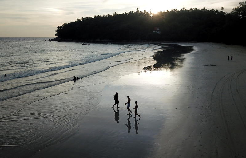 People walk on Kata beach on Thursday as Phuket reopens to overseas tourists. (Reuters photo)