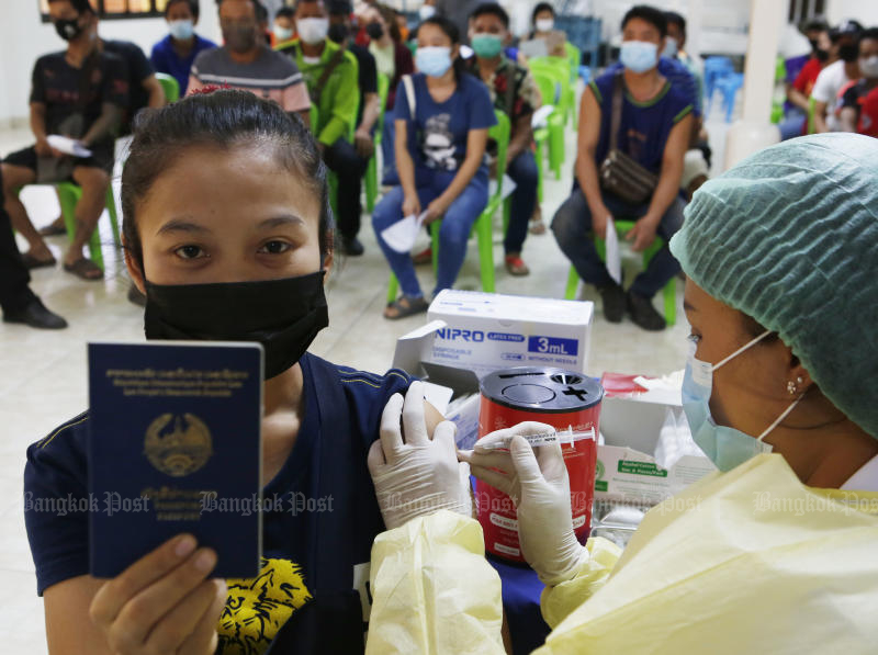 A Lao worker shows her passport as she receives the first Covid-19 vaccine jab at a vaccination centre in Lam Luk Ka district in Pathum Thani on Friday. (Photo: Apichit Jinakul) A Lao worker shows her passport as she receives the first Covid-19 vaccine jab at a vaccination centre in Lam Luk Ka district in Pathum Thani on Friday. (Photo: Apichit Jinakul)