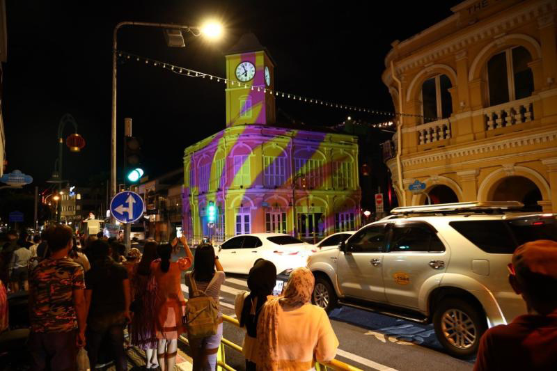 Tourists visit the old quarter of Phuket town, where the clock tower has been brightened up with lights and colours. (Photo: Tourism Authority of Thailand)