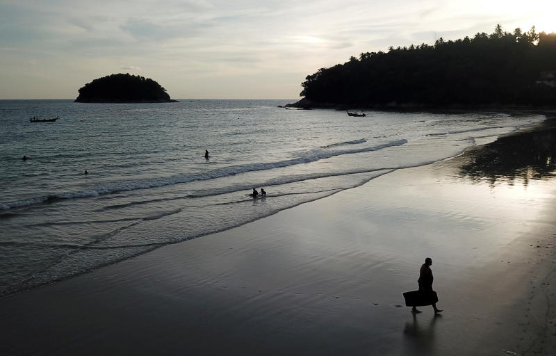 People enjoy the evening at almost empty Kata beach as Phuket reopens to overseas tourists on July 1, 2021. (Reuters photo)