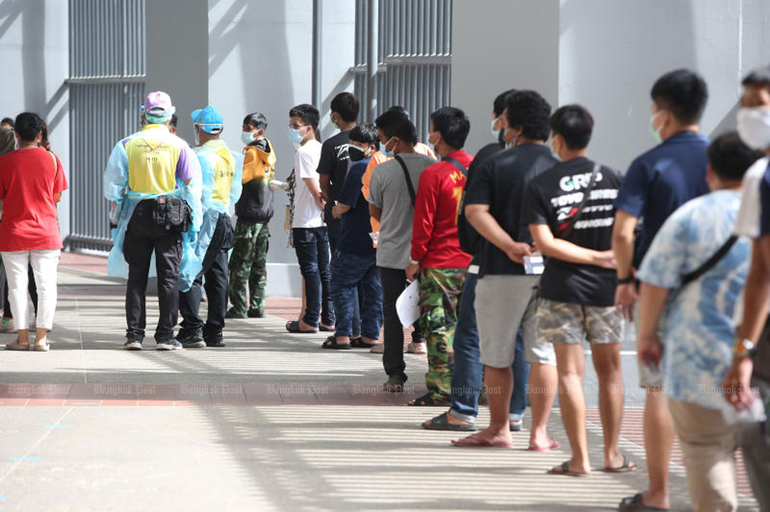 People queue up for rapid Covid-19 antigen testing at Bangkok's Rajamangala National Stadium on Tuesday. About 1,500 people sought to get tested. (Photo: Varuth Hirunyatheb)