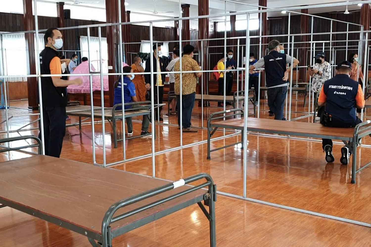 Workers set up a field hospital for Covid-19 patients in a hall at Wat Takhro in Khong district, Nakhon Ratchasima, on Friday. (Photo: Prasit Tangprasert)