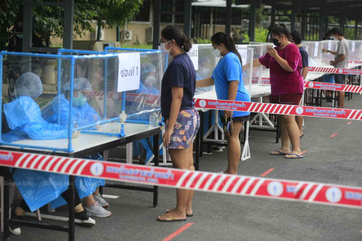 People get queue tickets for Covid-19 tests at Chandrakasem Rajabhat University in Chatuchak district, Bangkok, on Friday. (Photo: Pornprom Satrabhaya)