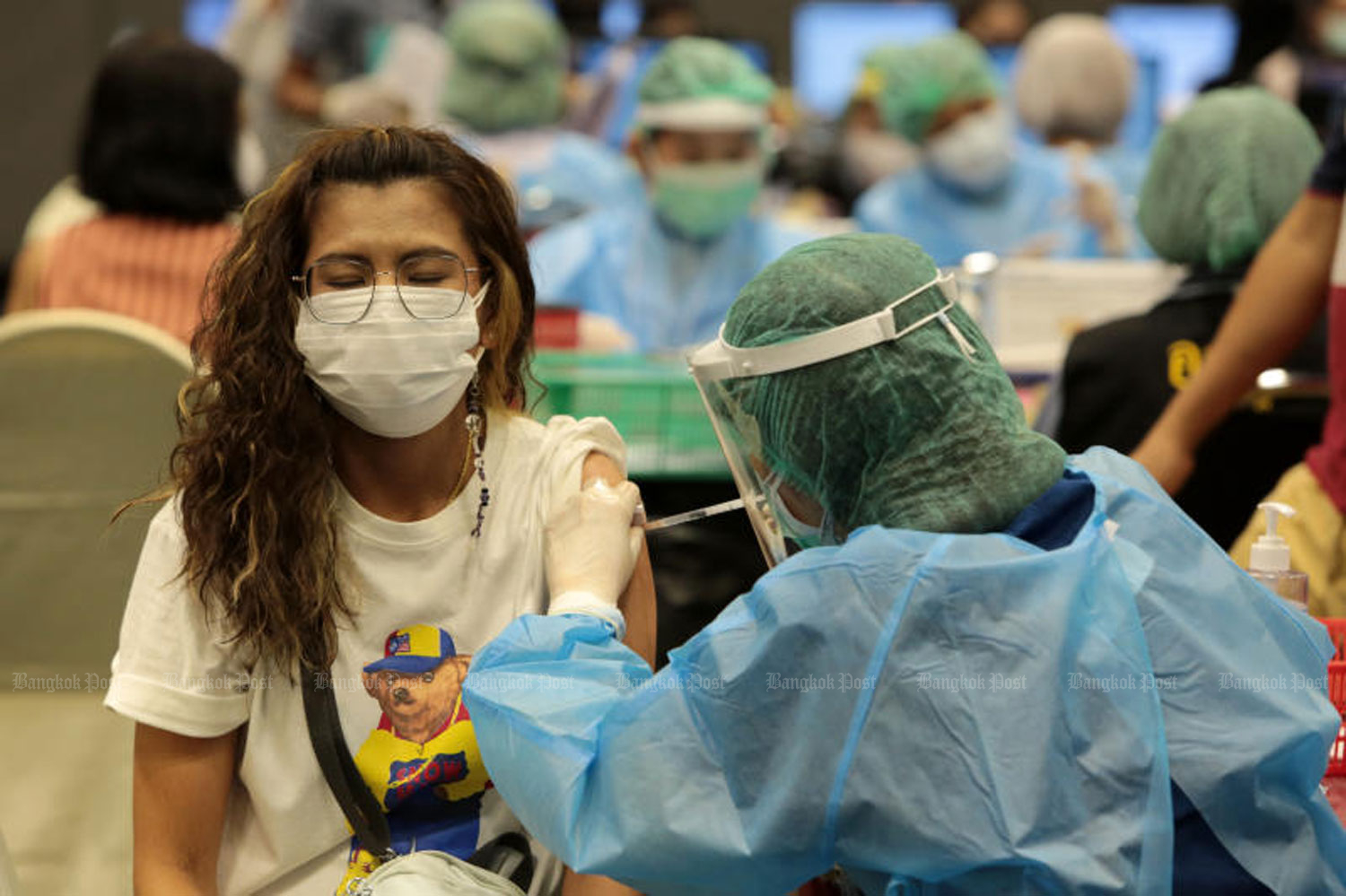 A health worker administers a Covid-19 vaccine jab to a woman at Central Plaza Westgate in Nonthaburi on July 16. (Photo: Chanat Katanyu)