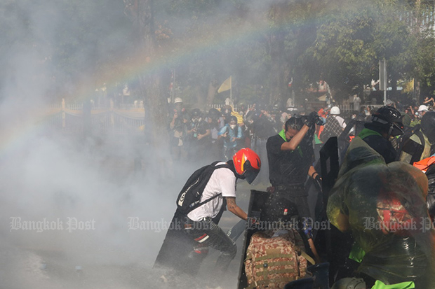 Anti-government protesters clash with police on Ratchadamnoen Avenue blocking their march to Government House on Sunday. (Photo: Arnun Chonmahatrakool)