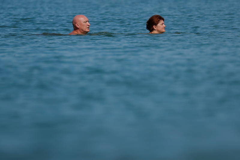 A couple enjoys a dip in the sea on Tuesday, as Phuket remains open to overseas foreigners who are fully vaccinated against the coronavirus. (Photo: Reuters)