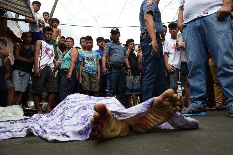 FILE PHOTO: Residents and policemen gather over the body of a suspect killed during an anti-drug operation at an informal settlers' area near a port in Manila, on Nov 10, 2016. (AFP) FILE PHOTO: Residents and policemen gather over the body of a suspect killed during an anti-drug operation at an informal settlers' area near a port in Manila, on Nov 10, 2016. (AFP)