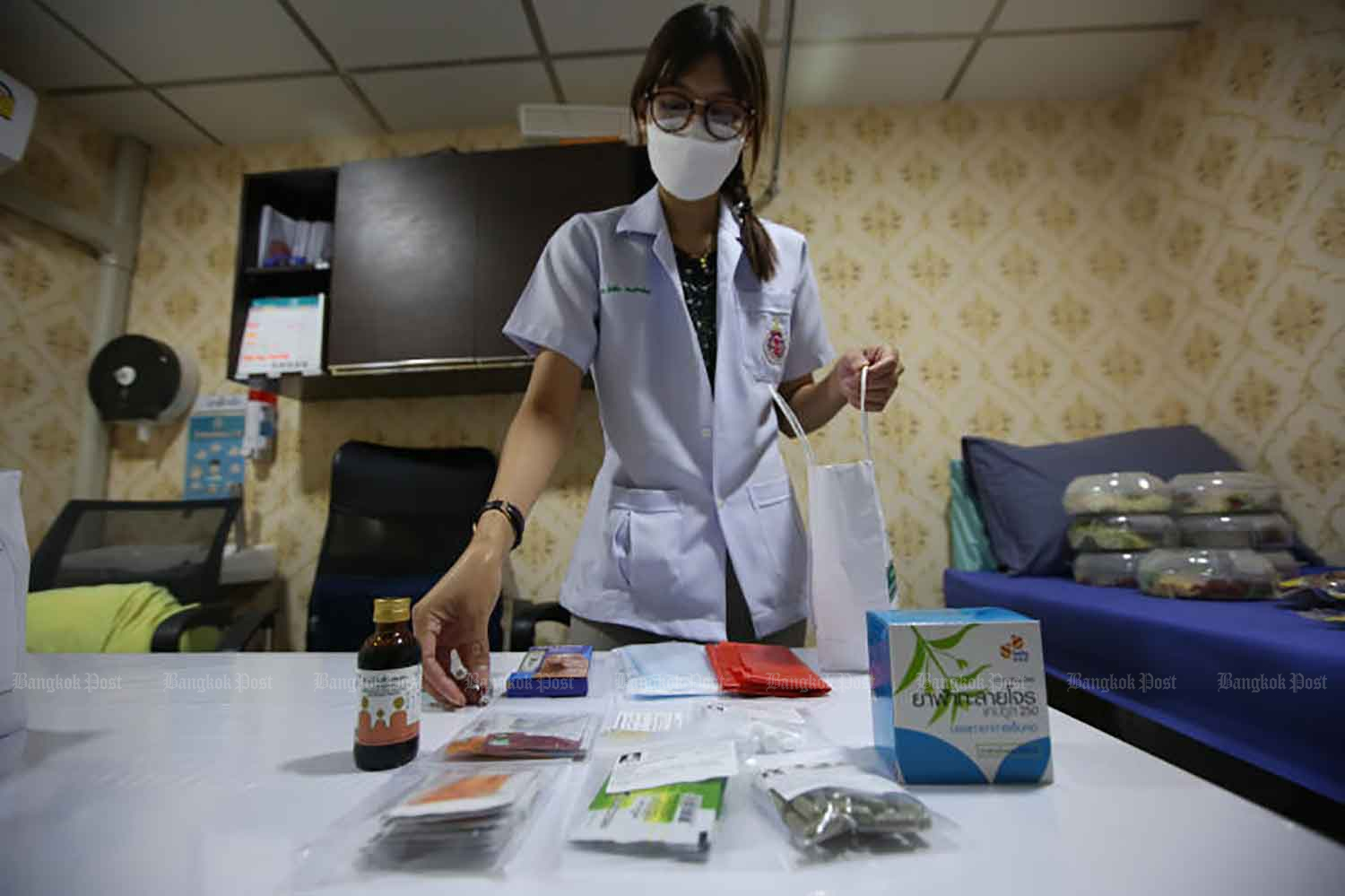 A doctor prepares medication to be delivered to Covid-19 patients under home isolation in Kannayao district of Bangkok on Wednesday. The programme allows those with mild symptoms to stay at home, in order to help ease workloads at hospitals. (Photo: Varuth Hirunyatheb)