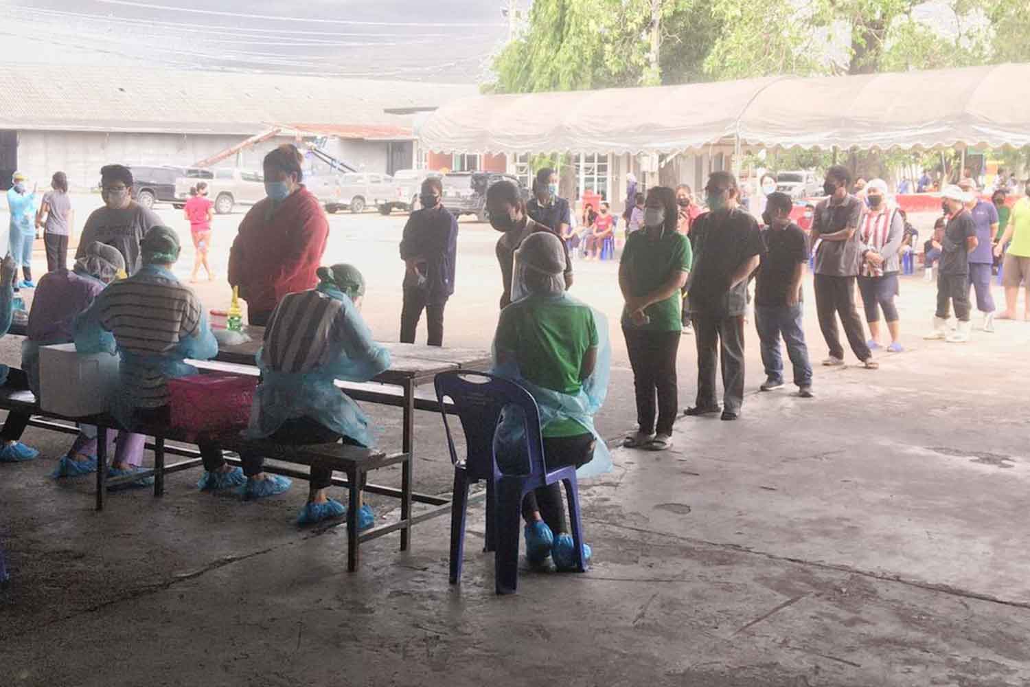 Workers queue up for Covid-19 tests at Vita Food Factory (1989) in Tha Maka district, Kanchanaburi, on Thursday. (Photo: Piyarat Chongcharoen)