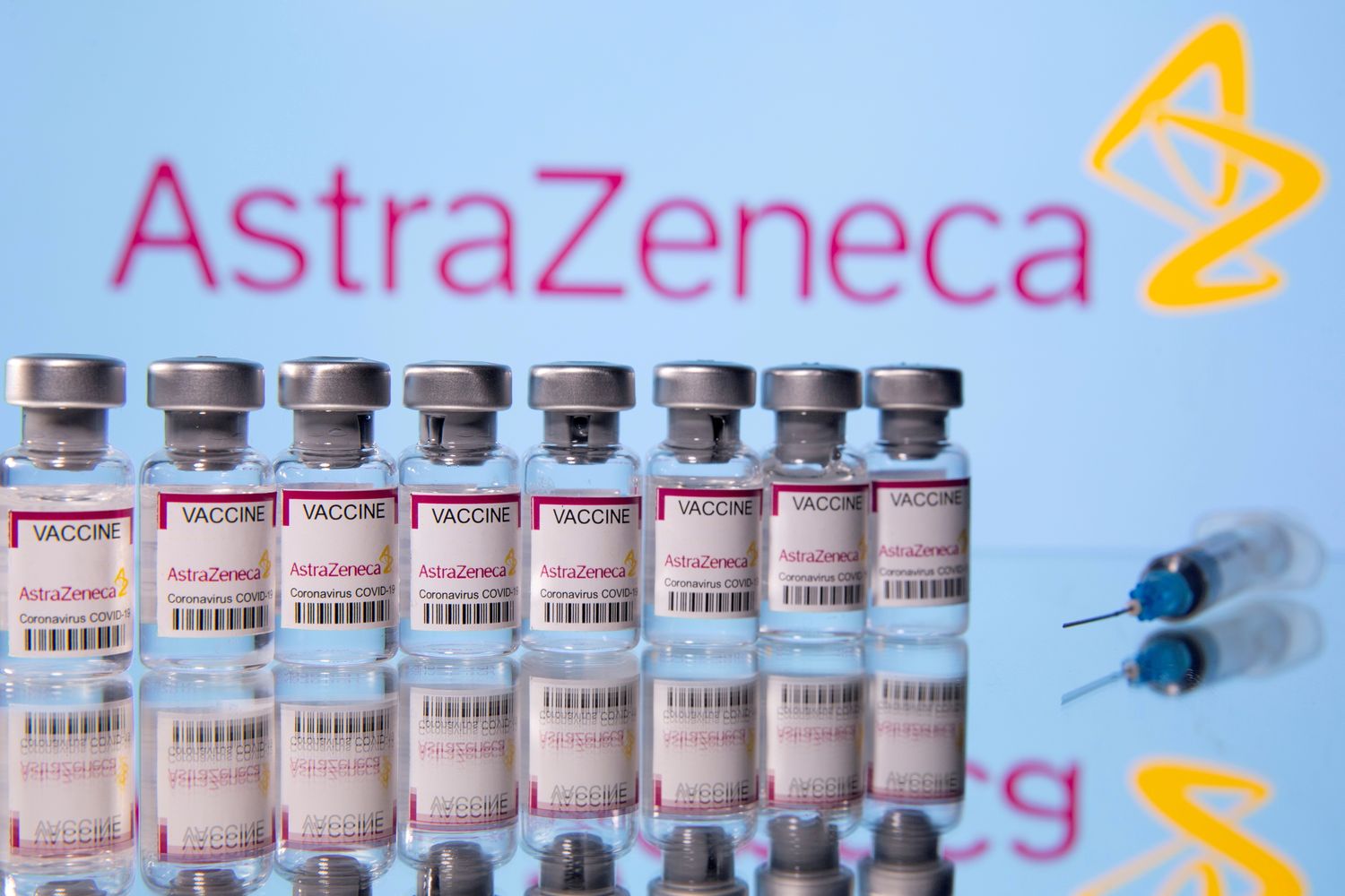 Vials labelled Astra Zeneca Covid-19 Coronavirus Vaccine and a syringe are seen in front of a displayed AstraZeneca logo, in this illustration photo taken March 14 this year. (Reuters photo)