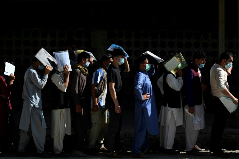 Afghan men line up to apply for a passport in Kabul, with a rush of applications ahead of the final withdrawal of foreign troops from the country. Afghan men line up to apply for a passport in Kabul, with a rush of applications ahead of the final withdrawal of foreign troops from the country.