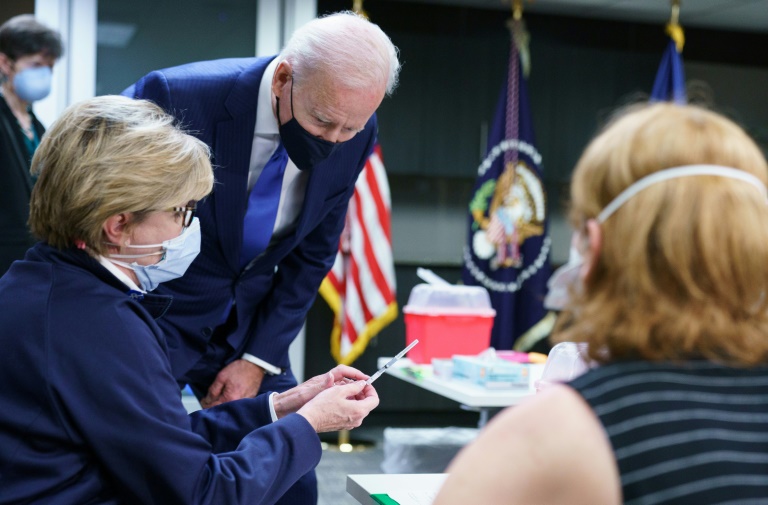 US President Joe Biden looks at a dose of vaccine before its administered at a Covid-19 vaccination site at the Washington DC Veterans Affairs Medical Center in Washington US President Joe Biden looks at a dose of vaccine before its administered at a Covid-19 vaccination site at the Washington DC Veterans Affairs Medical Center in Washington