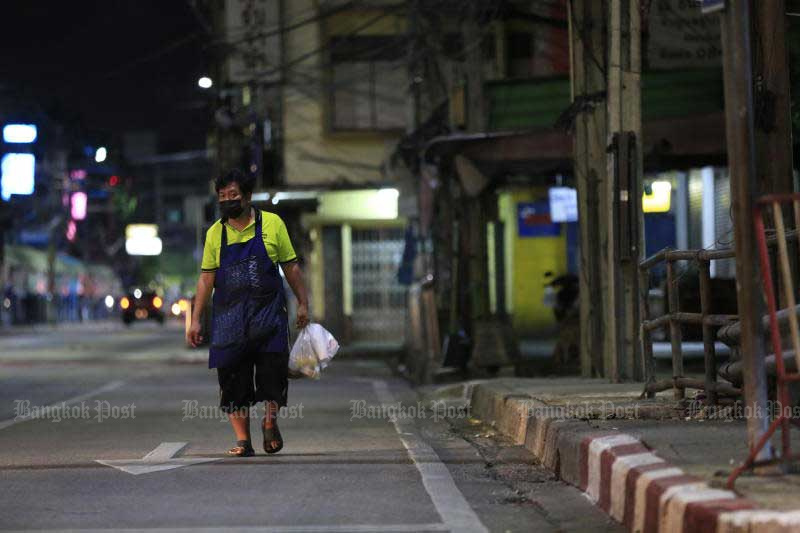 A woman walks along an empty road ahead of the curfew in the Nonthaburi municipality on July 24, 2021. (Photo: Pormprom Satrabhaya)