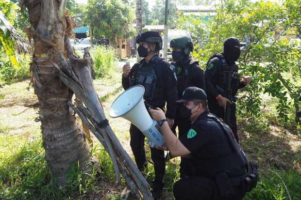 A security official tries to persuade Rosali Lamso to surrender as they surround a house in a rubber plantation in Nong Chik district in Pattani on Monday morning. (Photo: Abdullah Benjakat)